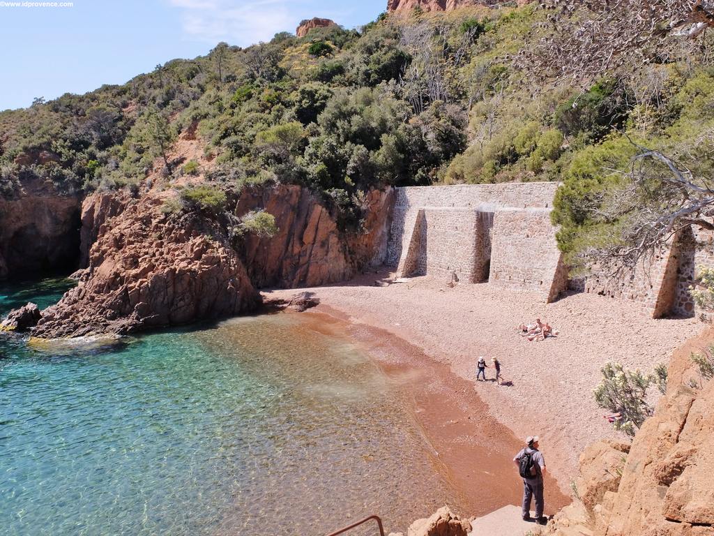 Der Strand St.Barthelemy am Mittelmeer, eingebettet in ockerfarbenen Felsen des Esterel Gebirges